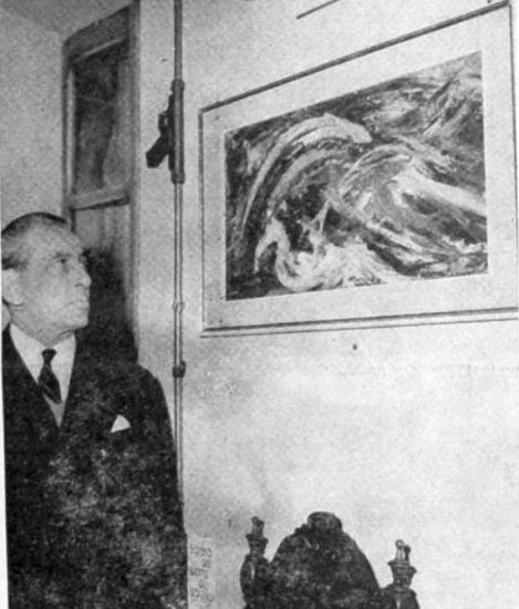 Ludovico Mares in front of one of his paintings at an exhibition