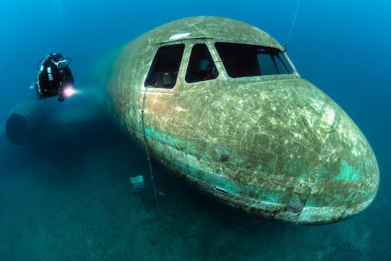 A diver (Caroline Robertson-Brown) explores a wreck of a plane, purposely sunk in a freshwater lake. The plane is a Hawker Siddeley (HS) 748. Capernwray Quarry, Lancashire, England, British Isles.